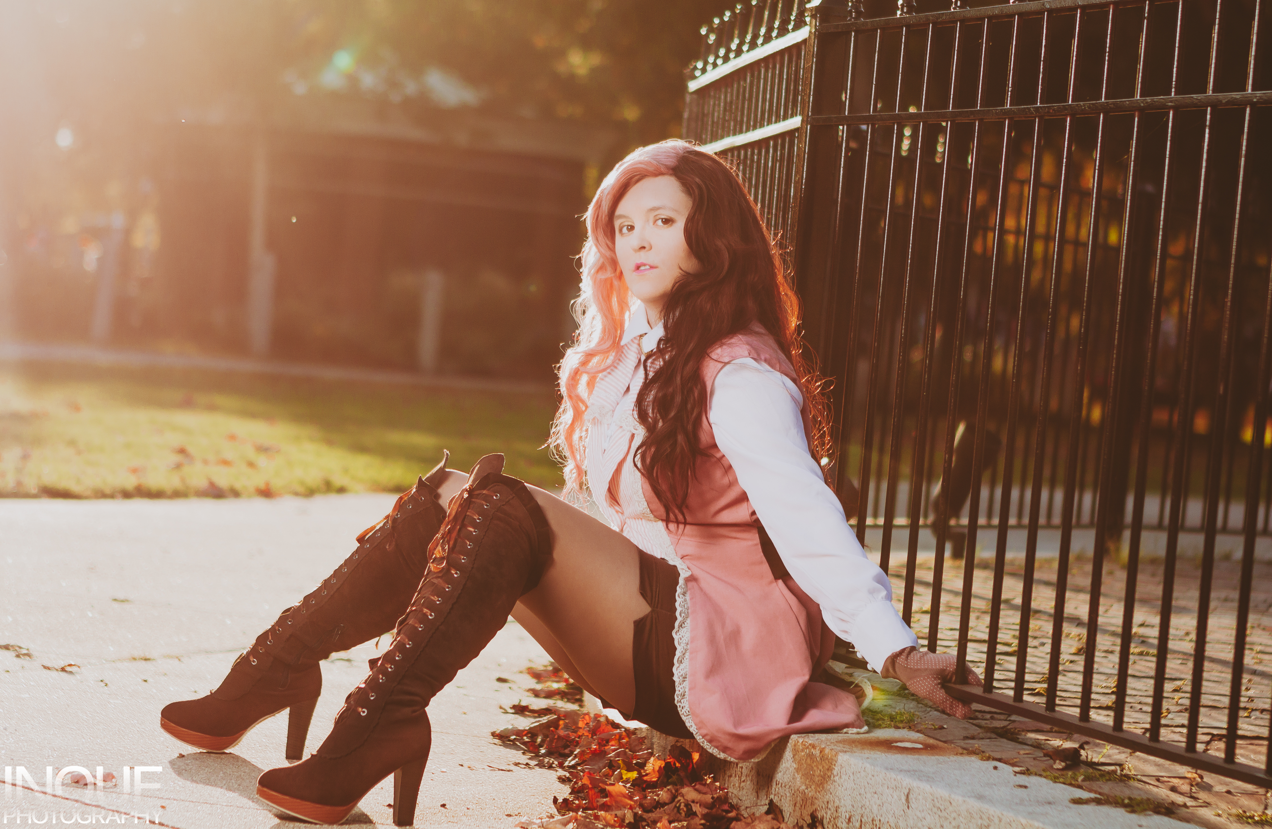 Neo sitting on the ground against an iron fence.