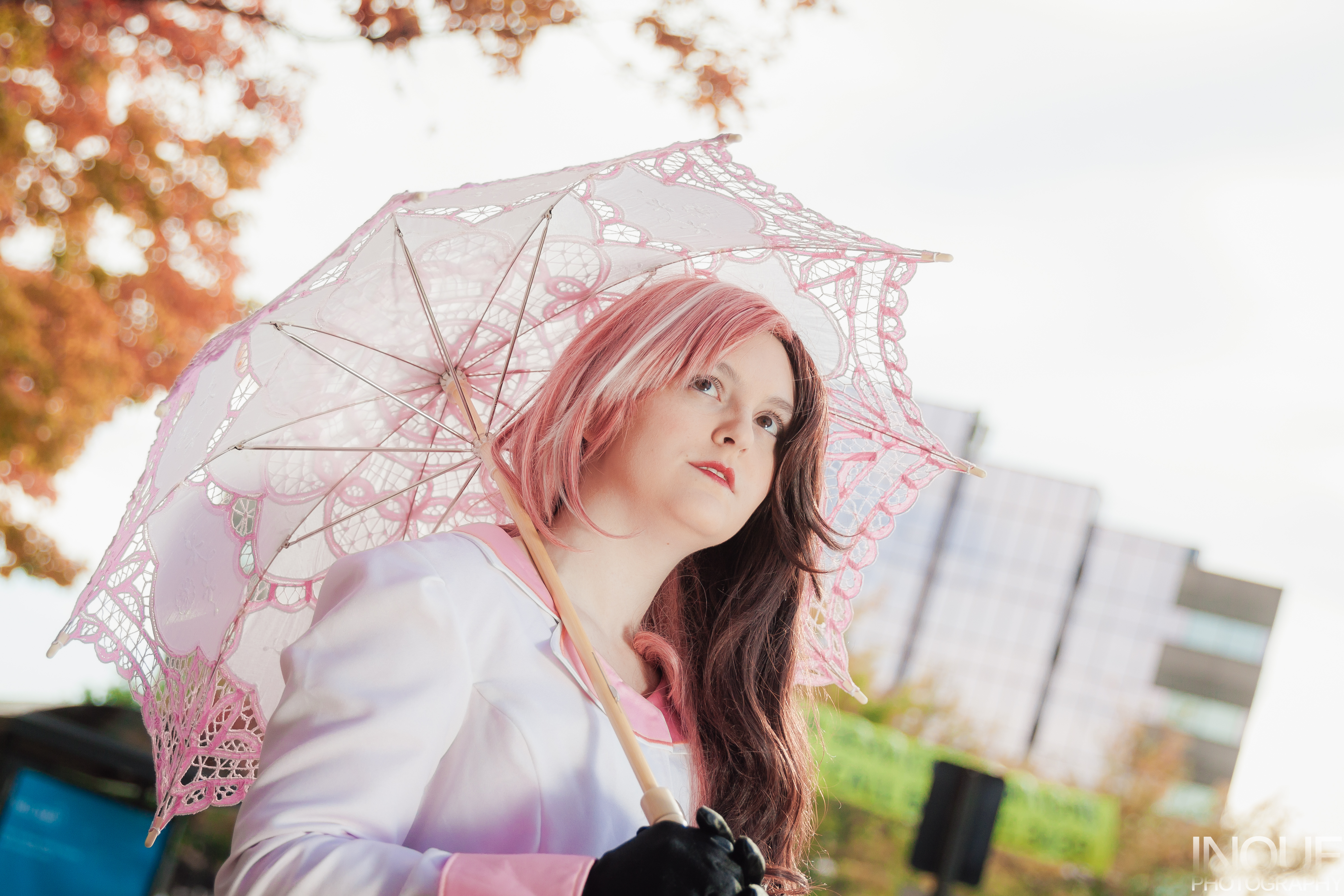 Neo looking up, holding a parasol over shoulder.