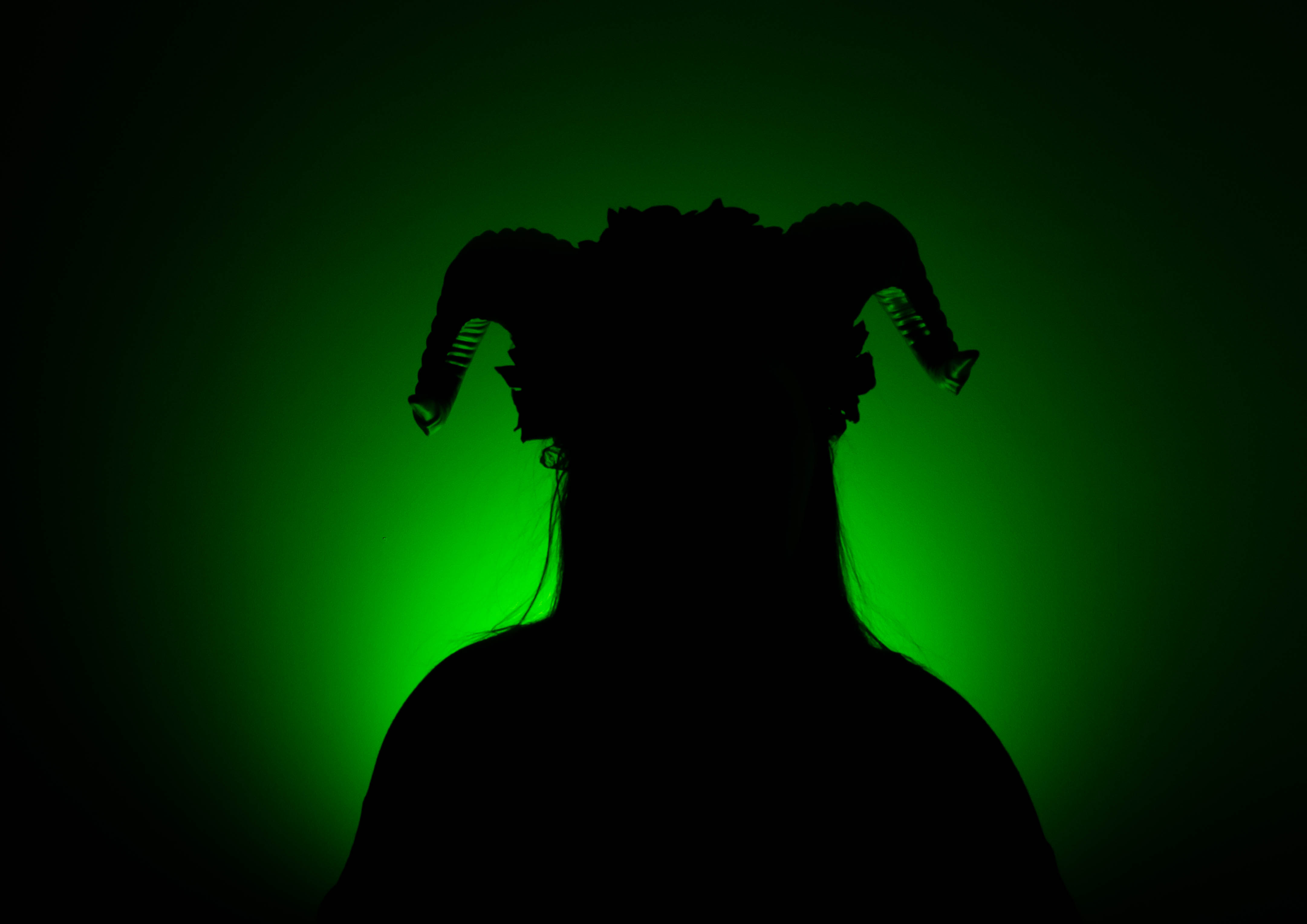 Shadow with horns against a green light background.